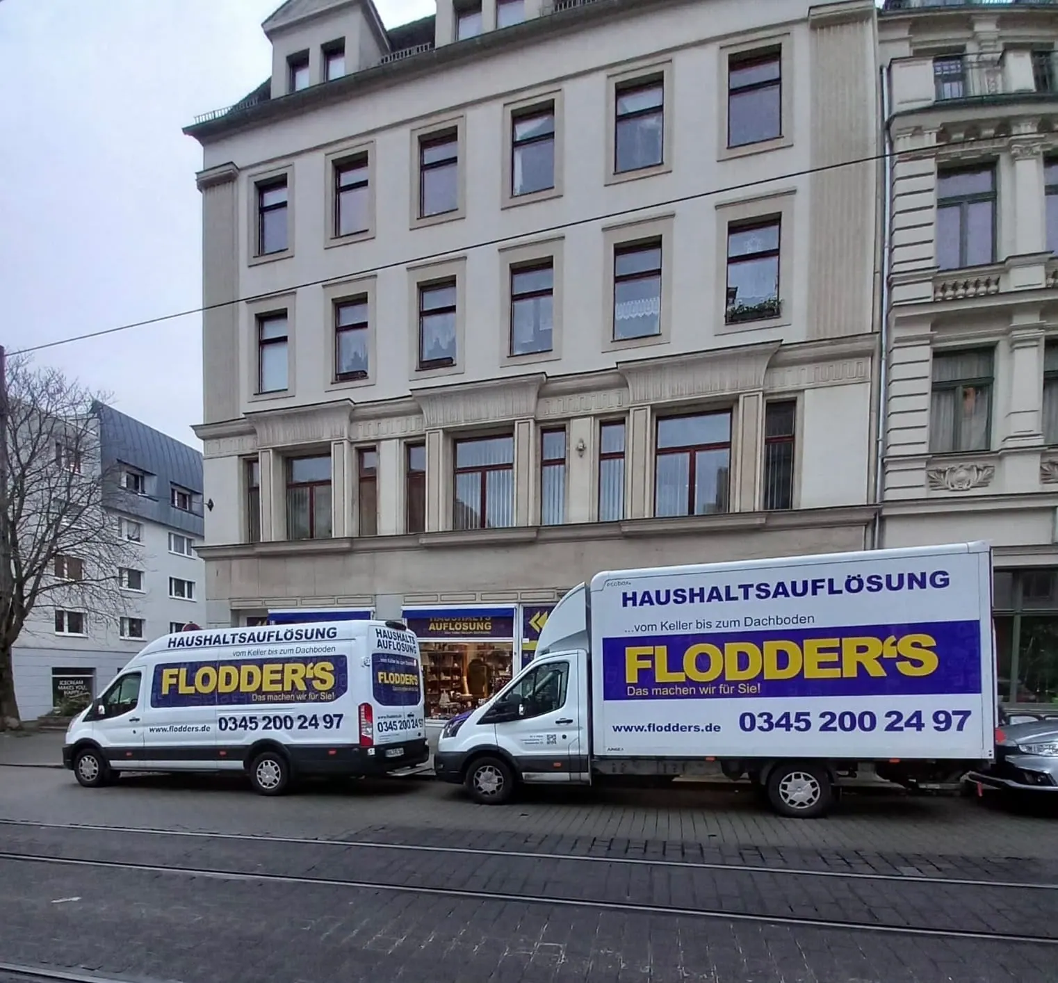 Zwei Transporter von Flodder's Haushaltsauflösung parken vor dem Ladengeschäft in Halle (Saale)
