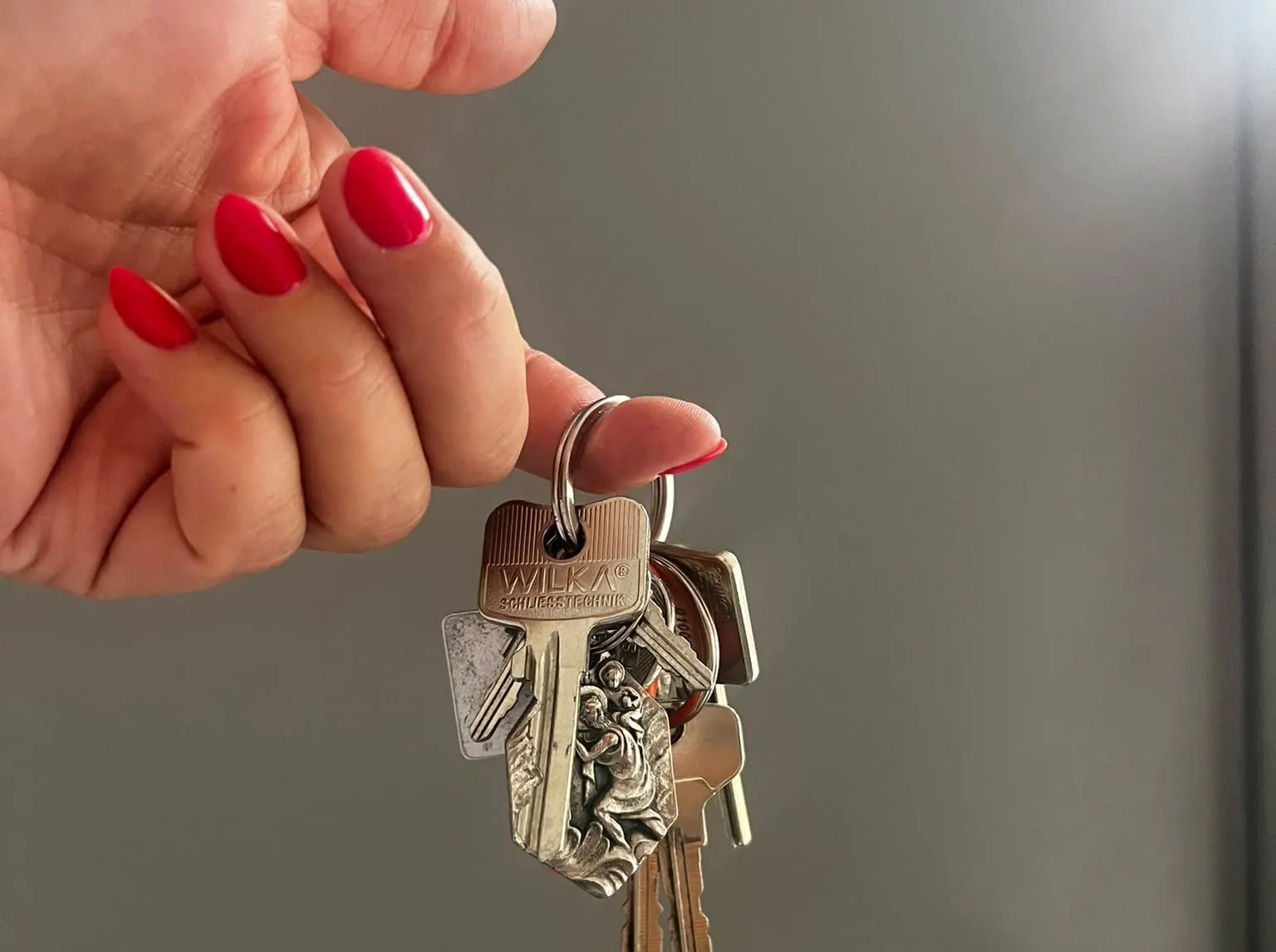 Hand übergibt einen Schlüsselbund vor einer Wohnungstür – besenreine Übergabe an den Vermieter in Halle (Saale)