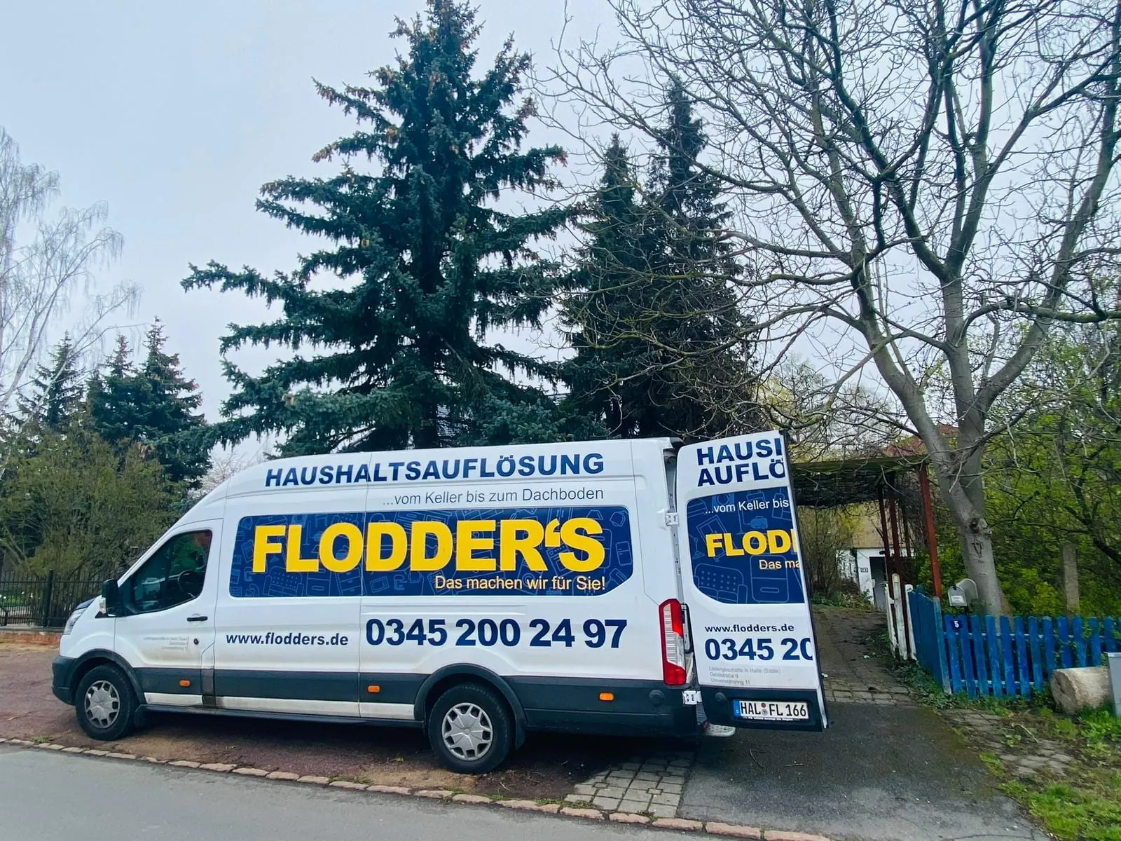 Transporter von Flodder's Haushaltsauflösung mit der Aufschrift „vom Keller bis zum Dachboden“ vor einem Objekt in Halle (Saale)